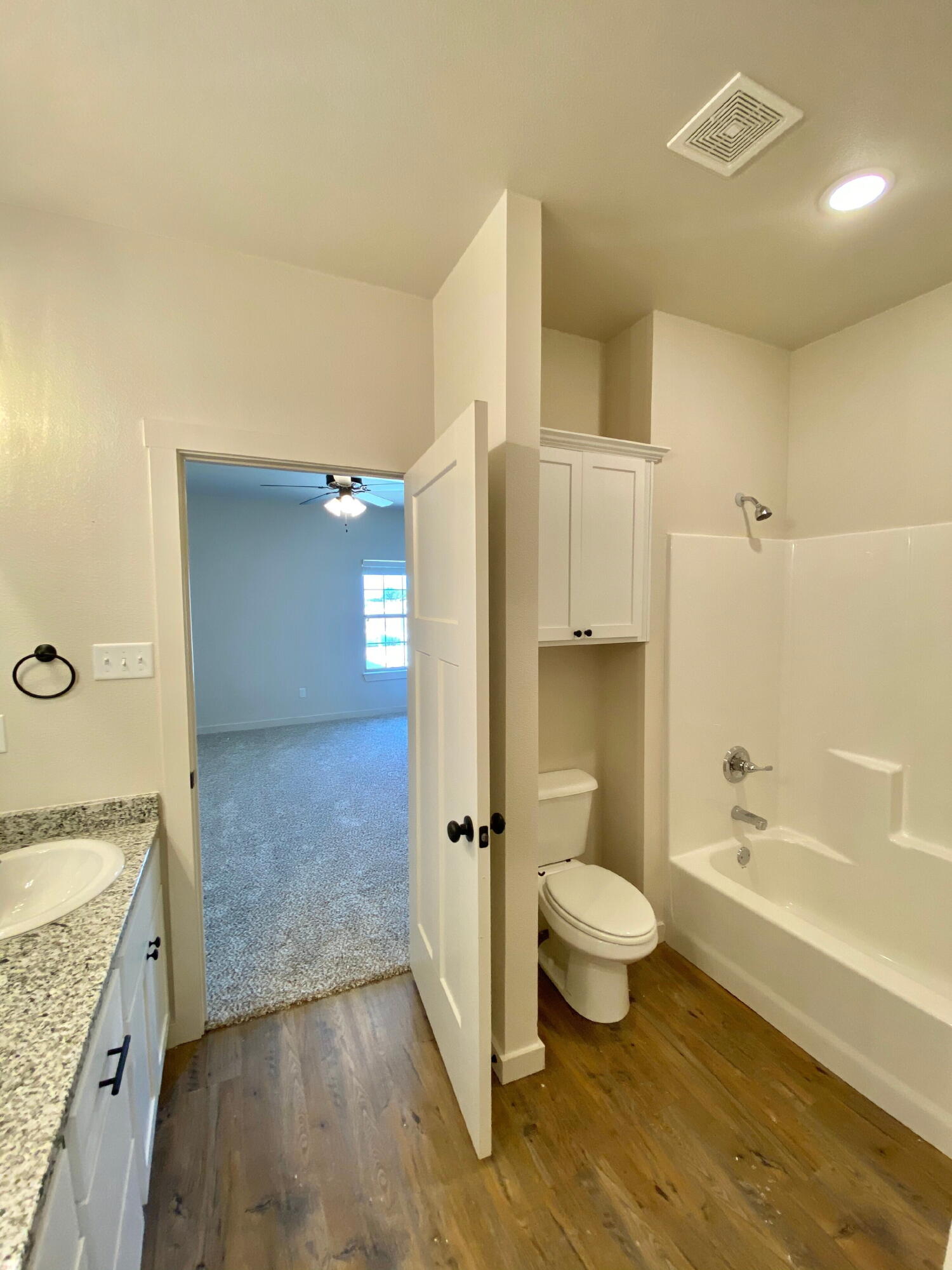 2729 137th Street Lubbock, TX 79423 - Photo 10 of 12 a bathroom with a granite countertop toilet a sink and bathtub