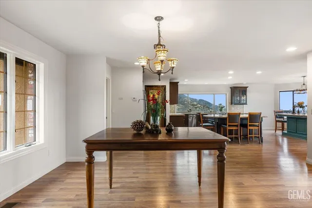 a view of a dining room and livingroom with furniture wooden floor a chandelier