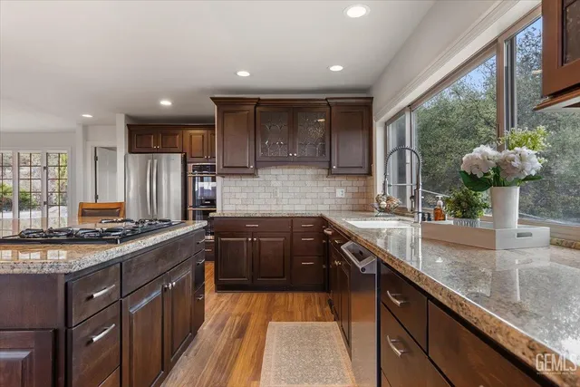 a dining room with wooden floor a chandelier a wooden table and chairs