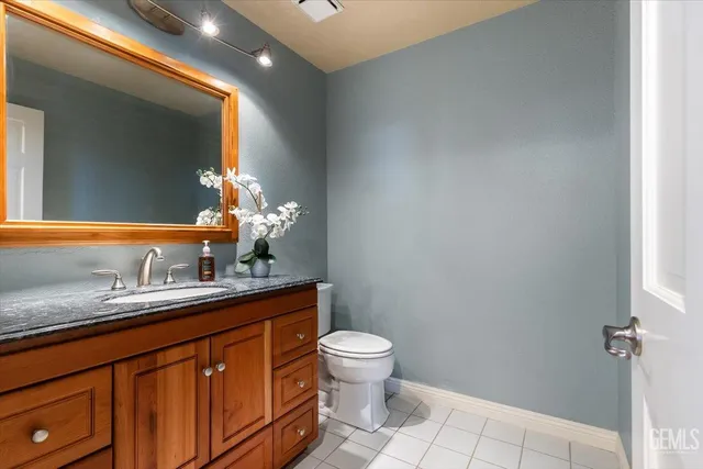 a bathroom with a granite countertop sink a toilet and a mirror