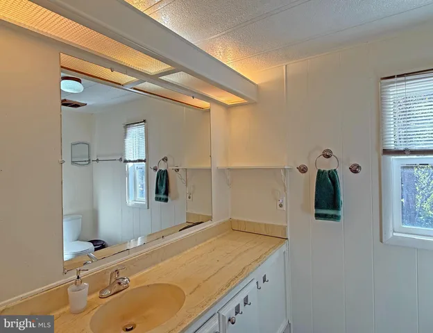 a bathroom with a granite countertop sink and mirror