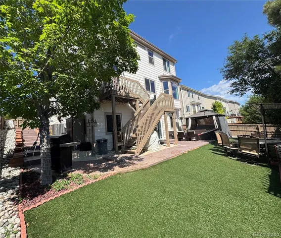 a view of a house with backyard and a tree