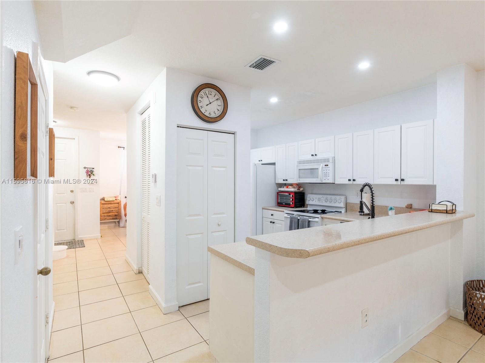9237 Southwest 227th Street, Unit 6 Cutler Bay, FL 33190 - Photo 11 of 41 a kitchen with a sink and a refrigerator