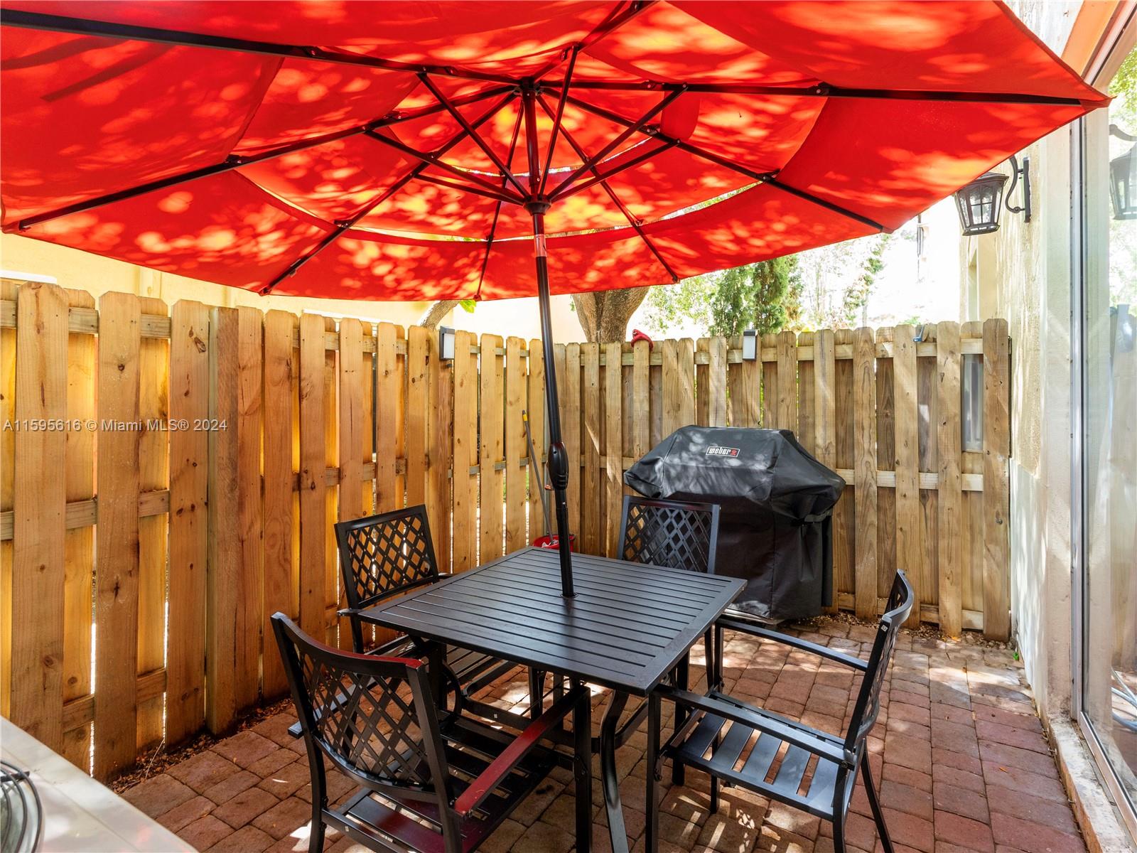 9237 Southwest 227th Street, Unit 6 Cutler Bay, FL 33190 - Photo 17 of 41 a patio table and chairs under an umbrella