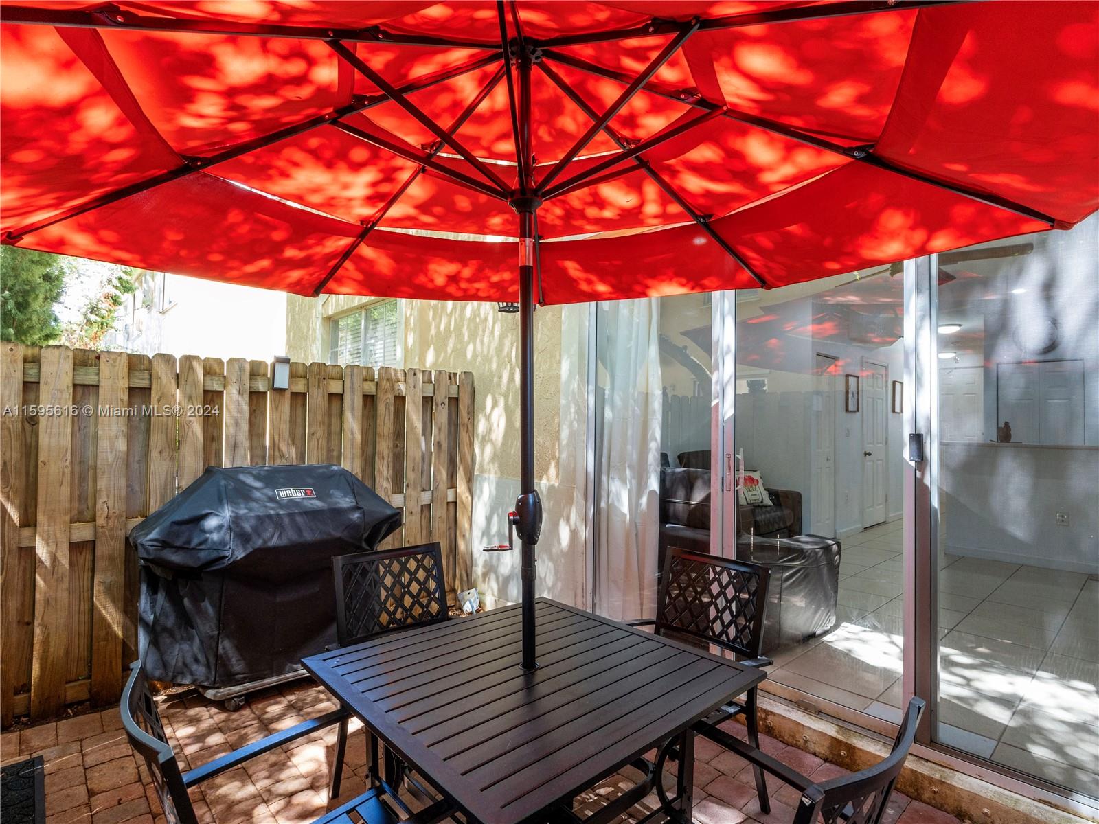 9237 Southwest 227th Street, Unit 6 Cutler Bay, FL 33190 - Photo 18 of 41 a backyard of a house with barbeque oven table and chairs