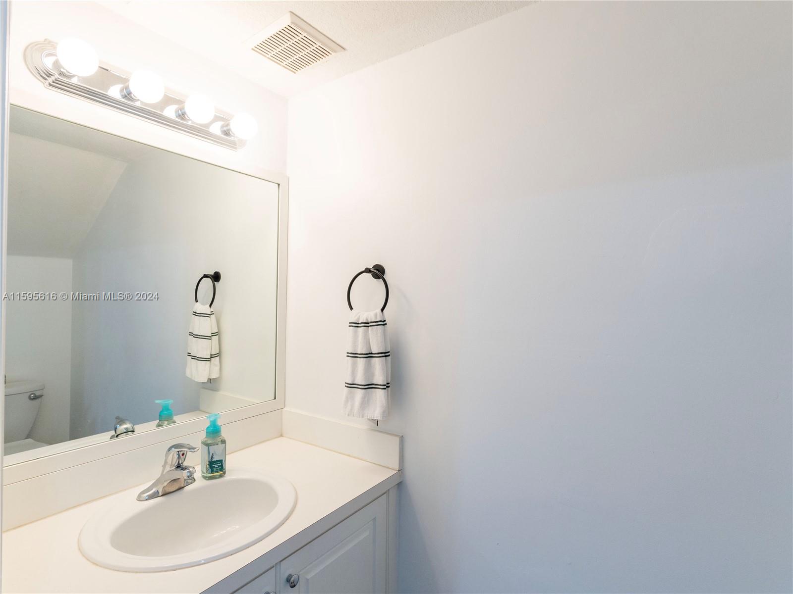 9237 Southwest 227th Street, Unit 6 Cutler Bay, FL 33190 - Photo 20 of 41 a bathroom with a sink and a mirror