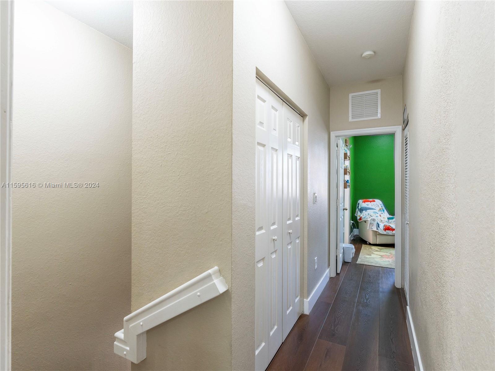 9237 Southwest 227th Street, Unit 6 Cutler Bay, FL 33190 - Photo 21 of 41 a view of a hallway with wooden floor and a bathroom