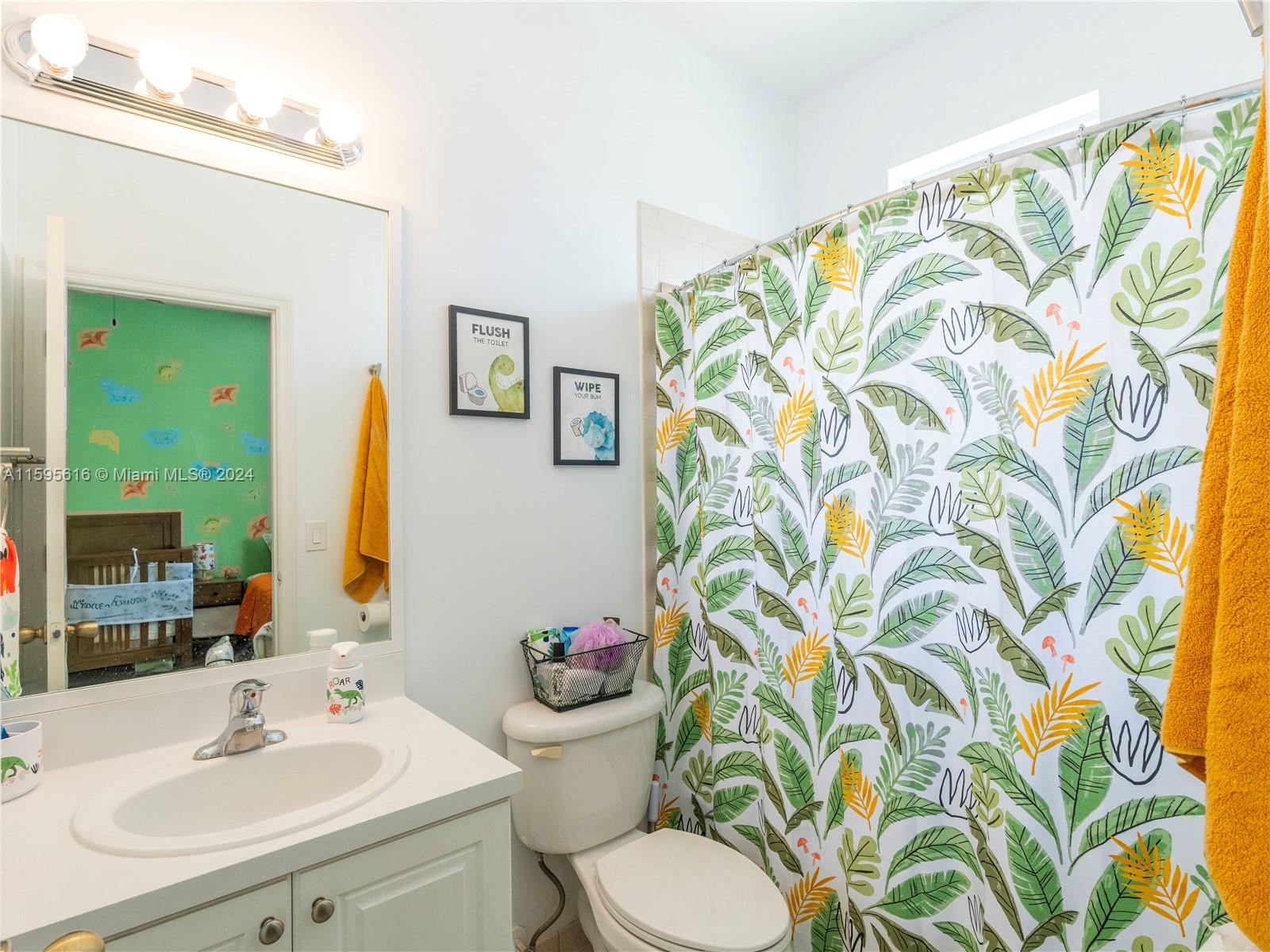 9237 Southwest 227th Street, Unit 6 Cutler Bay, FL 33190 - Photo 25 of 41 a bathroom with a sink and mirror with toilet