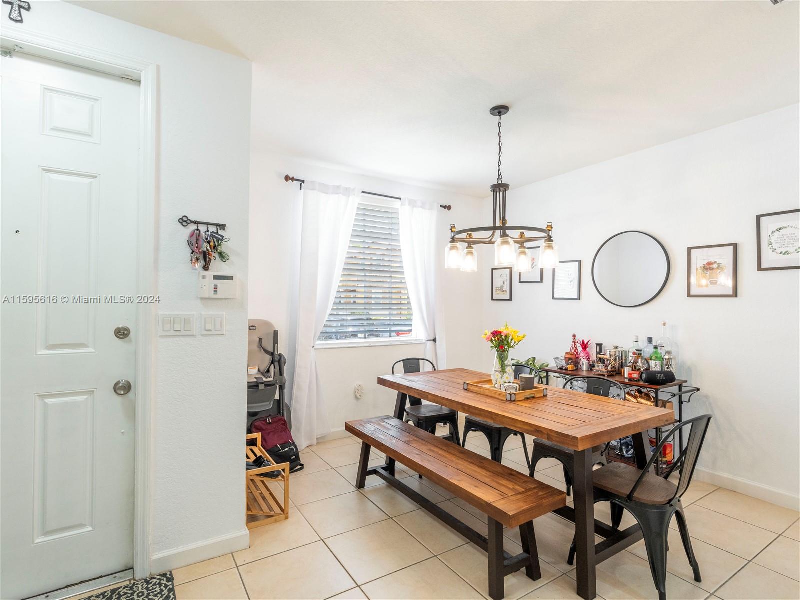 9237 Southwest 227th Street, Unit 6 Cutler Bay, FL 33190 - Photo 3 of 41 a dining room with furniture a rug and a chandelier