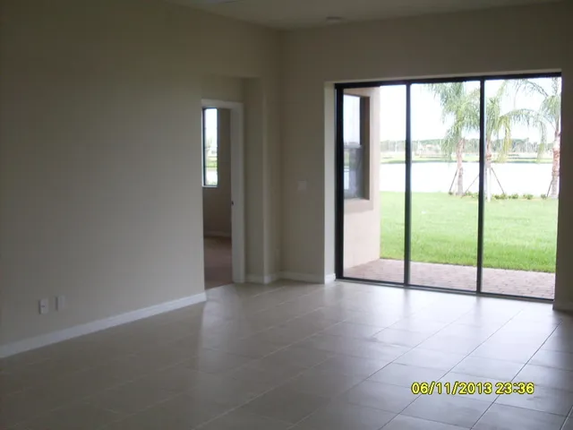 a view of an empty room with glass door and windows