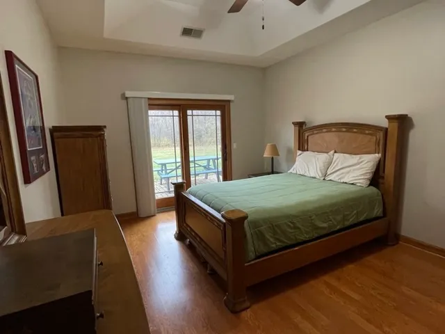 a bedroom with a bed a mirror on dresser and a window