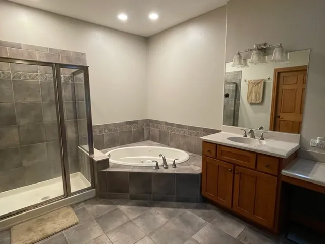 a bathroom with a tub sink and mirror