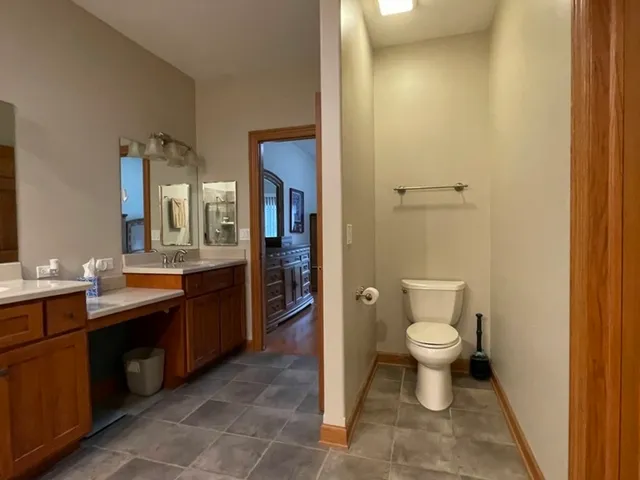a spacious bathroom with a sink a toilet and a mirror