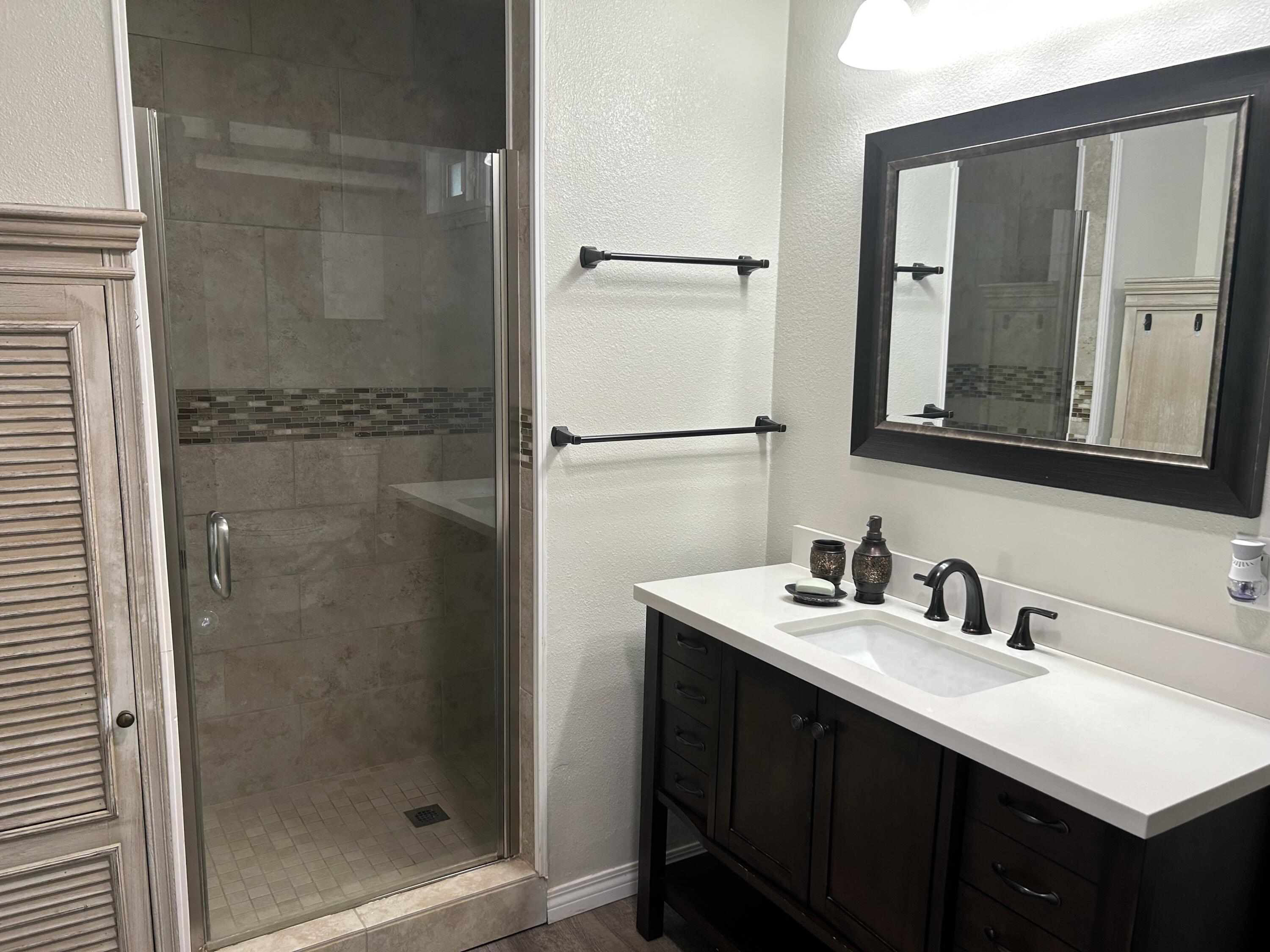 3344 West Ave L Lancaster, CA 93536 - Photo 6 of 9 a bathroom with a sink mirror and shower