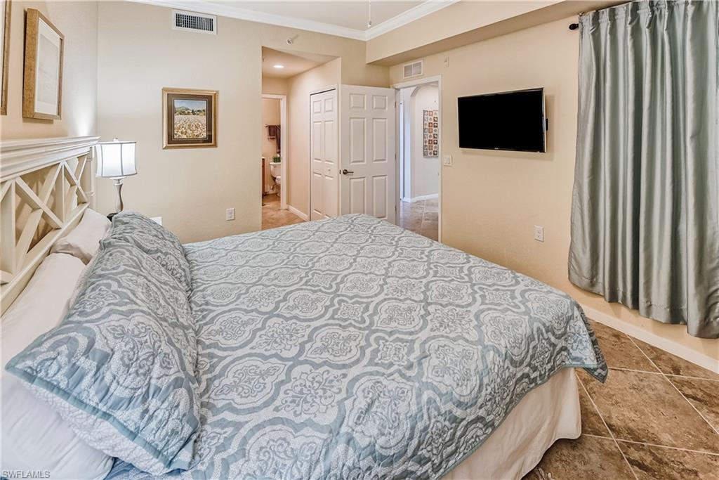 9735 Acqua Court, Unit 622 Naples, FL 34113 - Photo 11 of 34 a bedroom with a bed and a flat screen tv