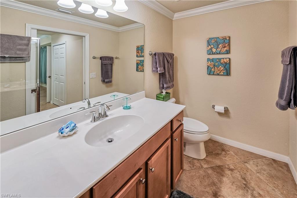9735 Acqua Court, Unit 622 Naples, FL 34113 - Photo 13 of 34 a bathroom with a sink mirror vanity and toilet