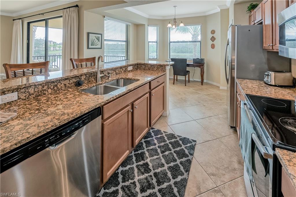 9735 Acqua Court, Unit 622 Naples, FL 34113 - Photo 7 of 34 a kitchen with a sink stove and cabinets
