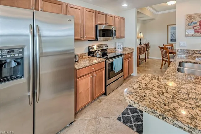 a kitchen with stainless steel appliances granite countertop a refrigerator stove and sink
