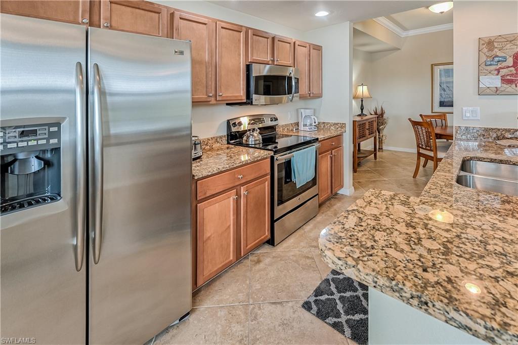 9735 Acqua Court, Unit 622 Naples, FL 34113 - Photo 8 of 34 a kitchen with stainless steel appliances granite countertop a refrigerator stove and sink