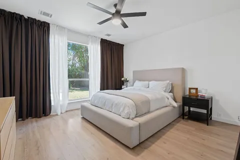 a large bed sitting in a bedroom next to a window