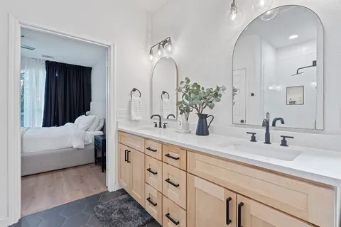 a bathroom with double vanity sink and a mirror