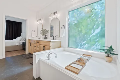 a living room with a bed furniture and a large window