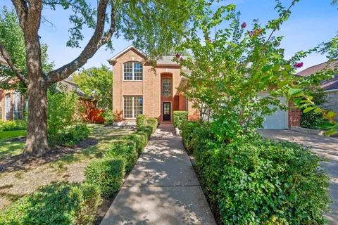a front view of a house with a yard and fountain in middle