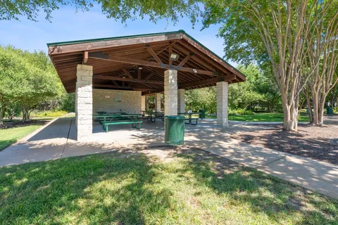 a sign board with a park park bench and trees