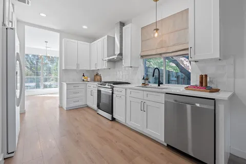 a kitchen with stainless steel appliances granite countertop a sink a stove a refrigerator and cabinets