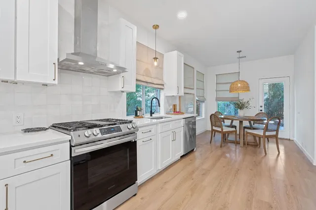 a kitchen with a stove and white cabinets