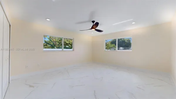 a large white kitchen with stainless steel appliances cabinets a sink and a counter top space