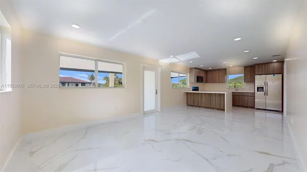 an empty room with ceiling fan and windows