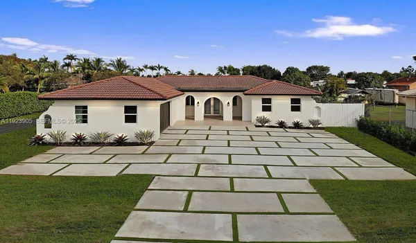 a front view of a house with a yard and a fountain