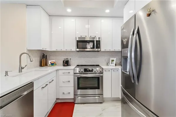a kitchen with stainless steel appliances a stove microwave and sink