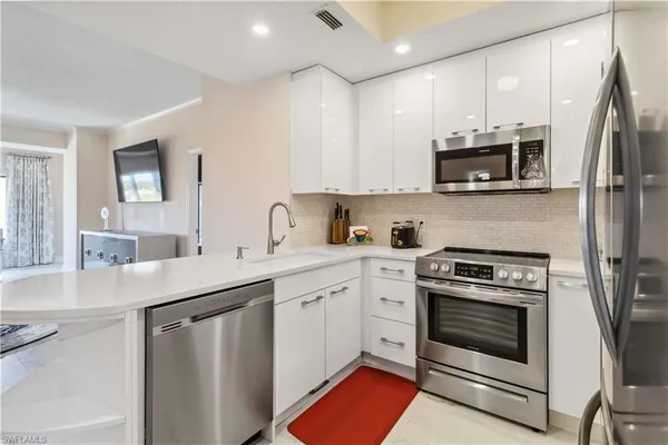 a very nice looking dining room with kitchen island granite countertop a table chairs and a chandelier