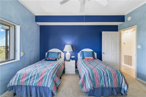 a spacious bedroom with two beds and a chandelier