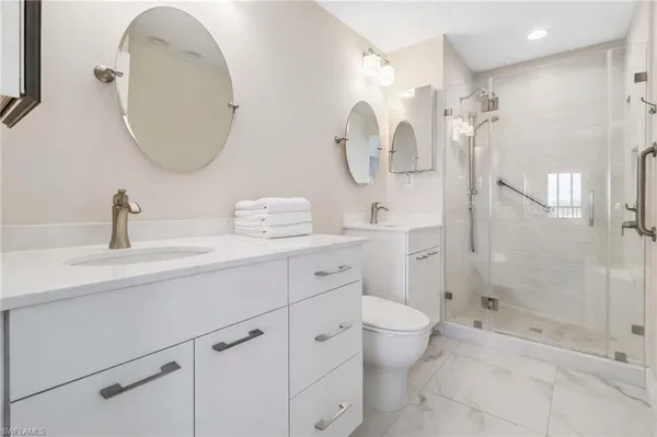 a bathroom with a double vanity sink mirror and toilet