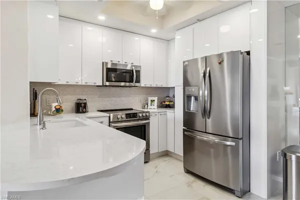 a kitchen with stainless steel appliances white cabinets and a stove top oven