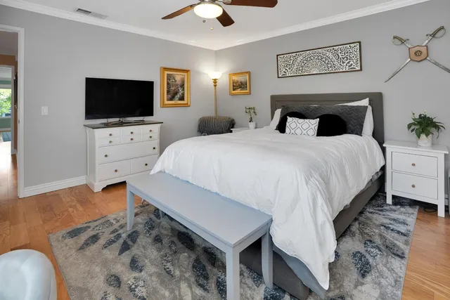 a spacious bedroom with a bed and a flat screen tv