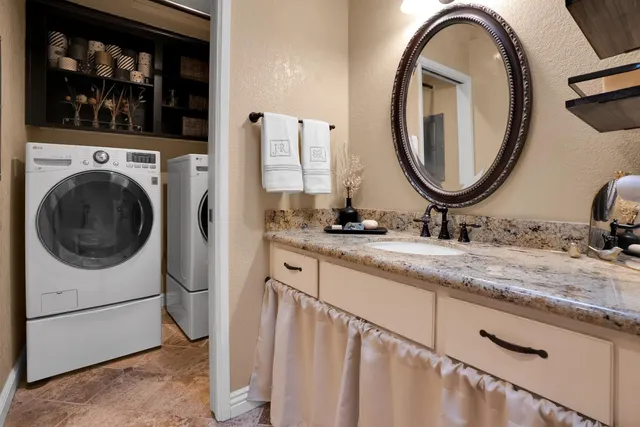 a bathroom with a granite countertop double vanity sink and a mirror