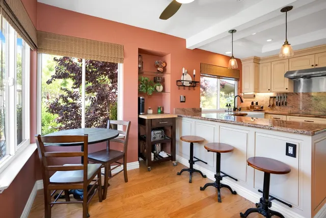 a kitchen with a sink a stove a dining table and chairs