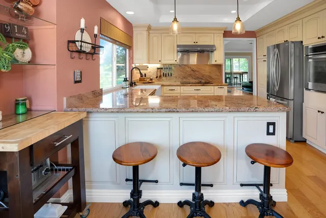 a kitchen with stainless steel appliances granite countertop a sink and a refrigerator
