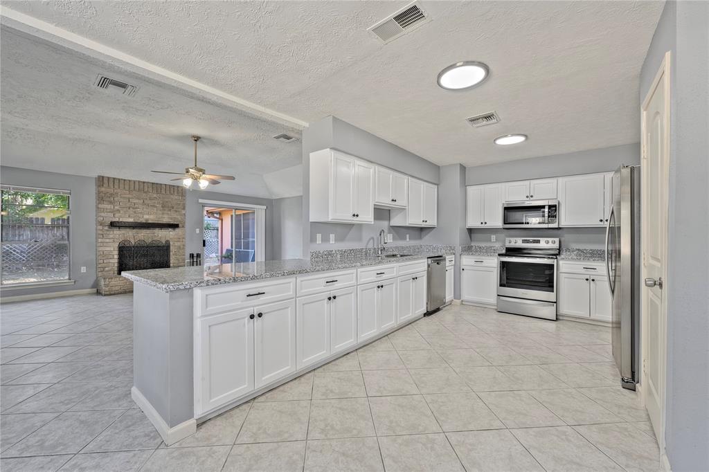 a large kitchen with cabinets stainless steel appliances and a counter space