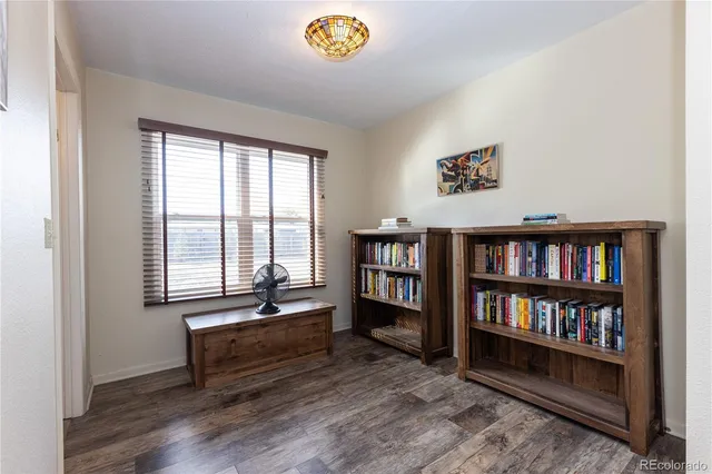 a view of an empty room with window and book shelf