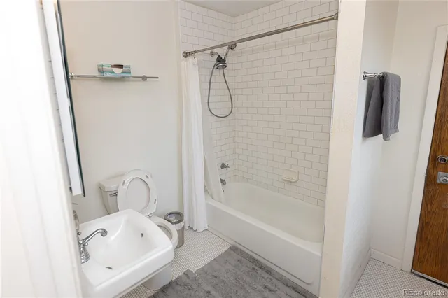 a bathroom with a tub a sink and a mirror