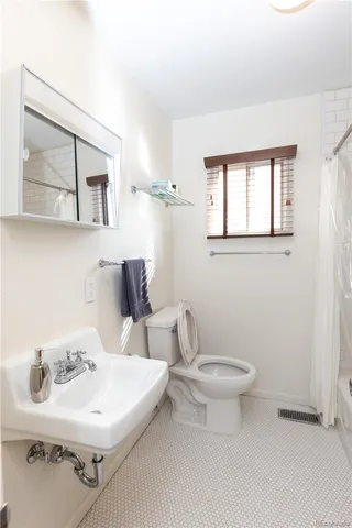 a bathroom with a sink toilet and a mirror