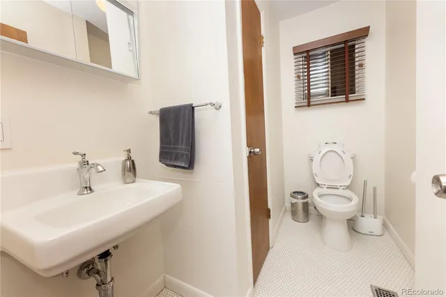 a bathroom with a toilet a sink and mirror