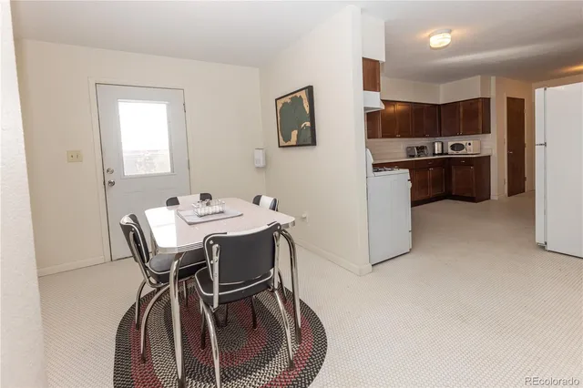 a dining room with furniture and kitchen view