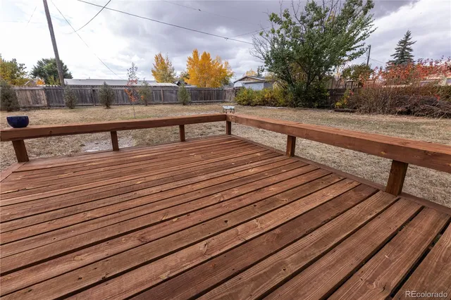 a view of a balcony with wooden floor and fence