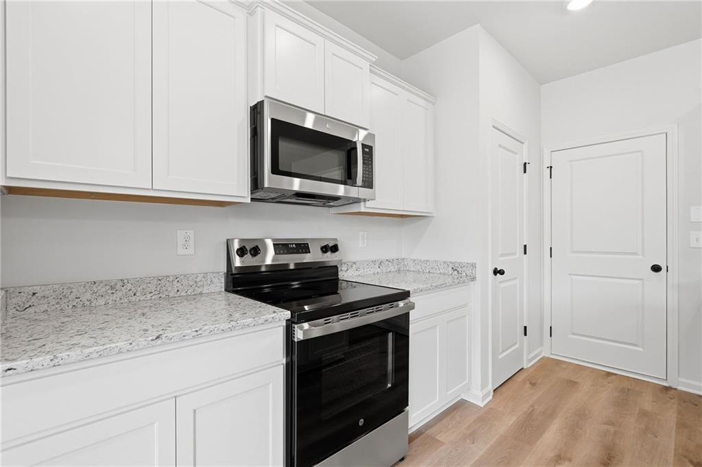 299 Summit View Lane, Unit 5 Jasper, GA 30143 - Photo 9 of 43 a kitchen with stainless steel appliances granite countertop white cabinets and a stove